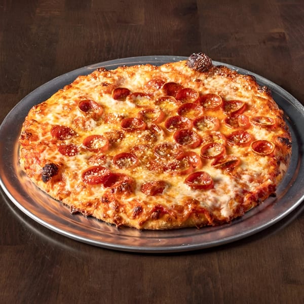A Krave It pepperoni pizza, with melted cheese and crispy crust, on a metal tray.